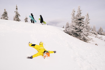 Family of snowboarders playing and have fun in snow on mountain top. Sunny holiday in ski resort