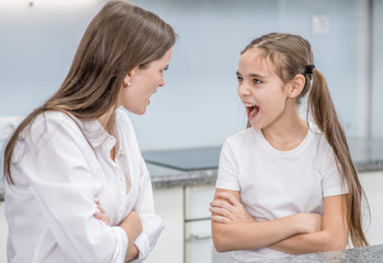 Fototapeta premium Mom and daughter shout at each other at home