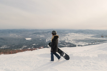Fototapeta na wymiar Snowboarder female enjoying the ski resort. Mountain landscape view, ski lift. Sheregesh. Russia