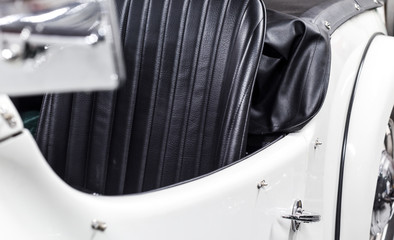 Restored classic car in white with black leather interior and chrome detail