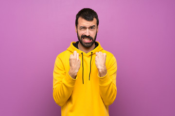 Handsome man with yellow sweatshirt frustrated by a bad situation