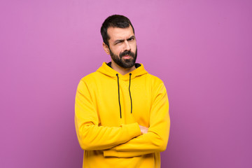 Handsome man with yellow sweatshirt feeling upset
