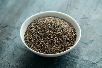 Organic Black Chia seeds in white bowl. Healthy super food.