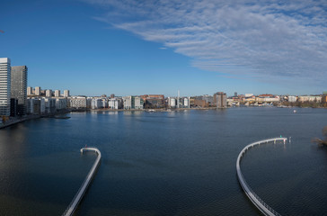 Obraz premium Sunny winter view over the bay between the Stockholm districts Marievikshamn, Årstadal, Tantolunden, Hornstull, Liljeholmen and the Årsta train bridges