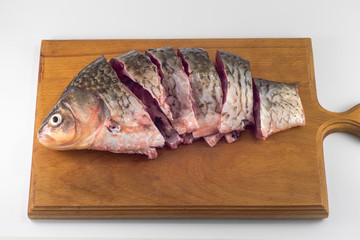 Chopped fresh crucian carp on a wooden cutting board