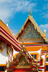 Fototapeta premium Sunny view of traditional ornate Thai architecture with golden spires in Bangkok, Thailand