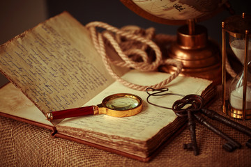 Old vintage items of the treasure hunter, traveler and discoverer - a magnifying glass, old manuscripts, a globe, keys to chests. The concept of luck, unexpected wealth, luck and romance.