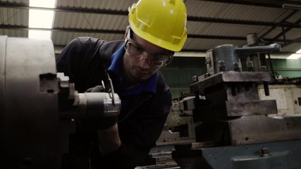Engineer workers wear a yellow safety helmet, use tools to check and repair the machine condition in the factory to be ready for production. Career and accident insurance concepts