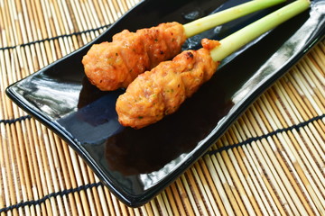 grilled chicken fermenting turmeric powder stabbing in lemon grass on plate