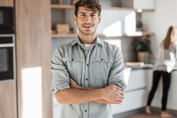 handsome young man standing in his kitchen.