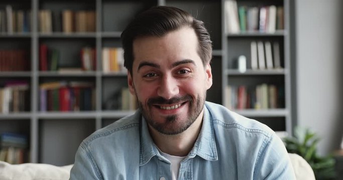 Smiling man look at camera talk make videocall at home