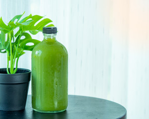 Green drink from fruite and vegetable in glass bottle with white background for healthy issue.