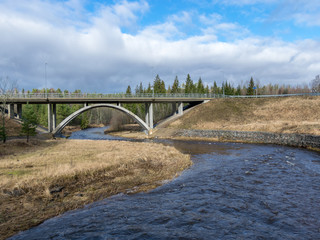 spring landscape with arched bridge over river