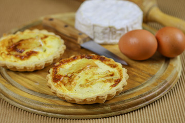 petites quiches au camembert sur une planche en bois