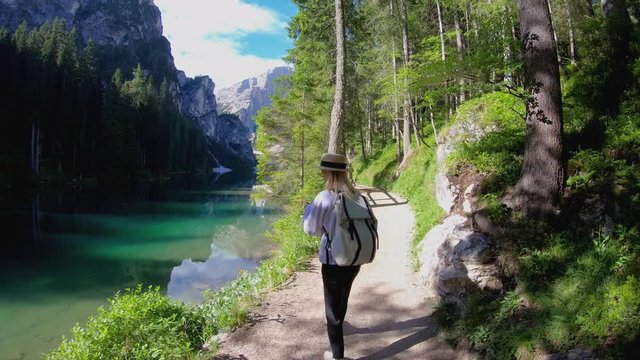 Caucasian woman wanderlust with backpack visiting piedmont valley of Italian alps with lake, positive millennial female travel blogger taking photo of nature landscape on smartphone device