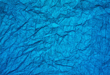 Texture of bright wrinkled blue paper. Background image.