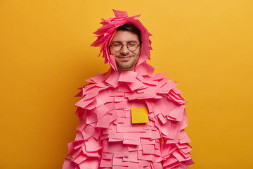 Positive guy has pink adhesive notes stuck around body and head, makes creative paper costume from...