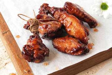  fried chicken wings on a marble surface, with spices and herbs.