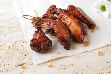  fried chicken wings on a marble surface, with spices and herbs.