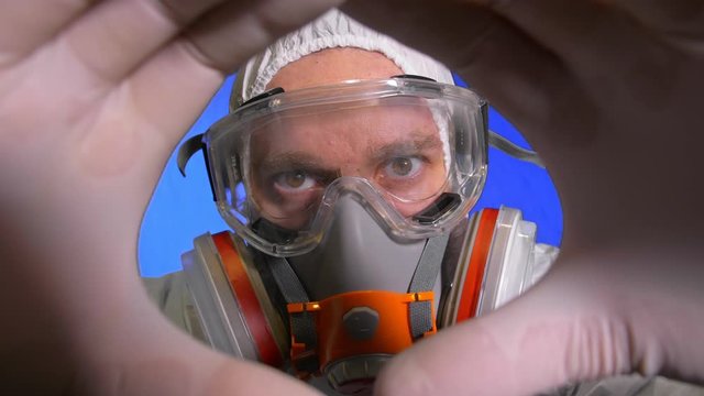 Scientist virologist in respirator. Slow motion. Man close up look, wearing protective medical mask. Concept health safety N1H1 virus protection coronavirus epidemic 2019 nCoV. Chroma key blue film.