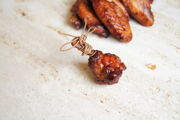 fried chicken wings on a marble surface, with spices and herbs.