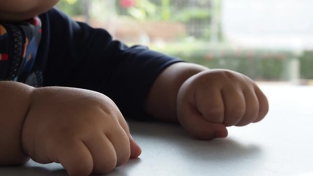 Hand of infant baby on the tabel.
