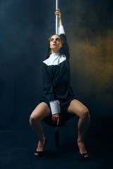 Sexy perverse nun in a cassock dances on a pole
