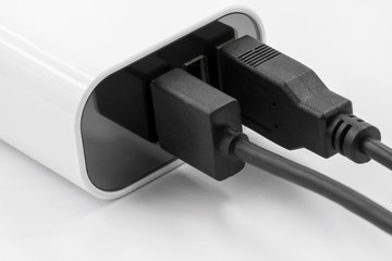 White socket travel charger for three USB ports output. Electronics device charger on white...