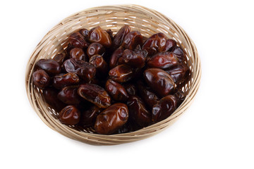Date fruits on wicked plate isolated on white