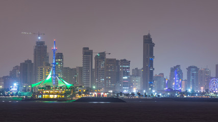 Skyline with Skyscrapers night timelapse in Kuwait City downtown illuminated at dusk. Kuwait City, Middle East