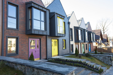 Modern hitech townhouses in a residential building settlement with green outdoor facilities in diffrent styles along the road