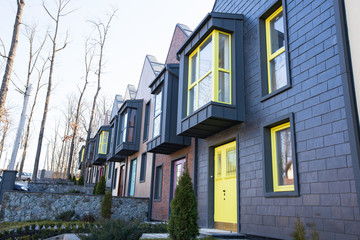 Modern hitech townhouses in a residential building settlement with green outdoor facilities in diffrent styles along the road
