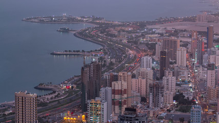 Fototapeta premium Skyline with Skyscrapers day to night timelapse in Kuwait City downtown illuminated at dusk. Kuwait City, Middle East