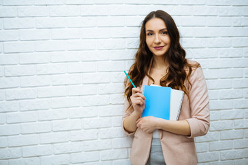 businesswoman standing near white brick wall © ostap_davydiak