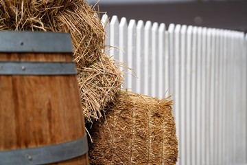 close up view on old wooden vine barrel by hay stacks in countryside