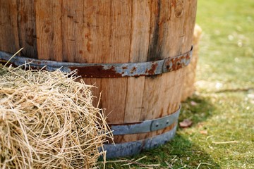 old wooden vine barrel behind haystack in farm