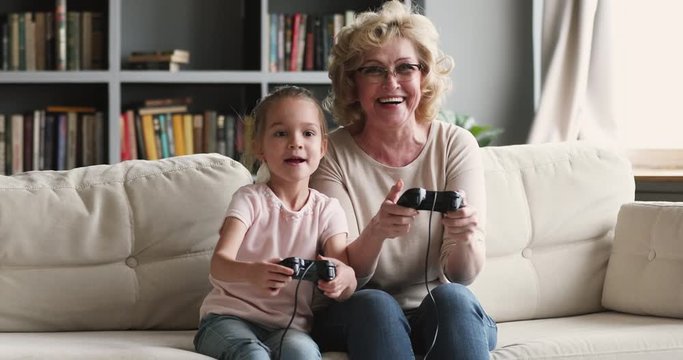 Funny excited two generations family gamers play video game at home