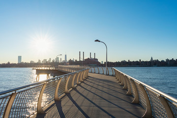 Empty Pier at Transmitter Park in Greenpoint Brooklyn New York over the East River with a view of the Manhattan Skyline before Sunset - obrazy, fototapety, plakaty