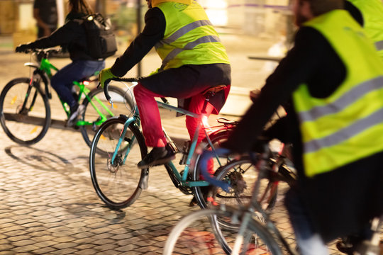 Radfahrer mit Warnewesten im abendlichen Stadtverkehr