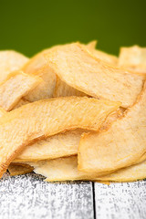 Slices of dried melon. Chips from melon on the white wooden table