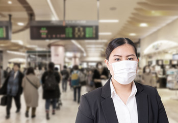 Fototapeta na wymiar Asian woman wearing surgical mask to prevent flu disease Corona virus with blurred image of crowded