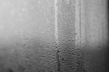 Rainy background with flowing down water drops on window glass