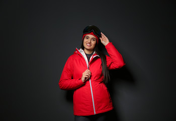Woman wearing stylish winter sport clothes on black background