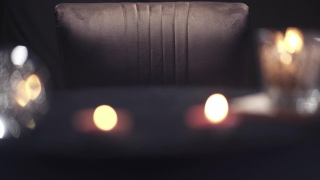 An empty black magician armchair standing in front of a table