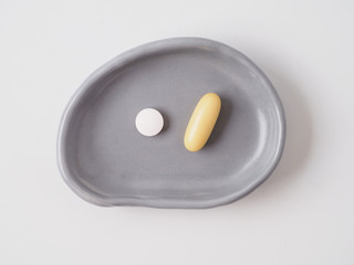 Medical pills in the plate isolated on white background.