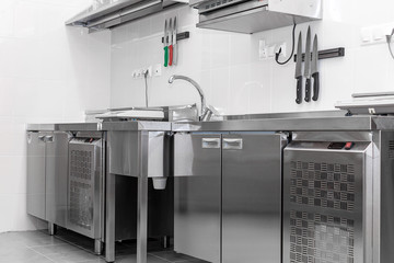 Design of the working area of the commercial cafe kitchen with stainless steel equipments, hot shop, food industry.