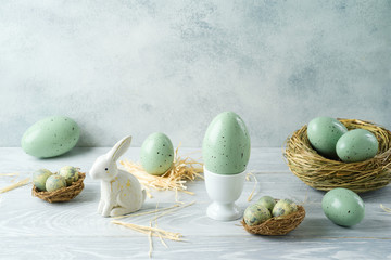 Easter holiday decorations with easter eggs, bunny and bird nest on wooden table
