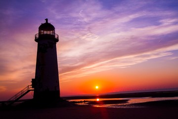 Coastal photograph of a lighthouse at sunset