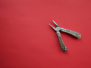 Multi tool with steel handles on a white colored background. Top view