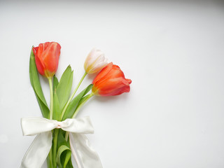 Bouquet of tulips with white ribbon isolated on white background. Top view.